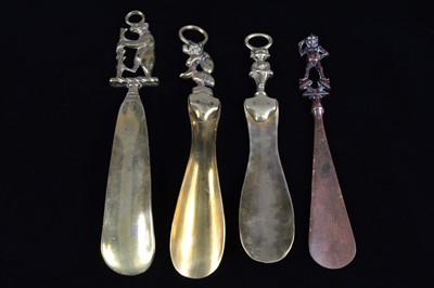 Lot 467 - Four heavy brass shoehorns