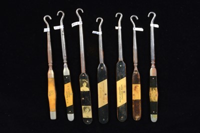 Lot 483 - Seven late 19th or early 20th Century monochrome flattened oval lozenge plastic handled button hooks