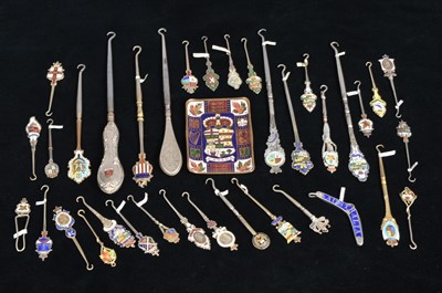Lot 494 - A collection of coloured enamel terminal souvenir button hooks and loops