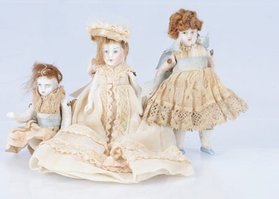 Lot 394 - Three all- white bisque dolls' house dolls
