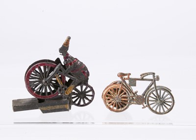 Lot 527 - Two cast-metal Penny Toy cycling whistles