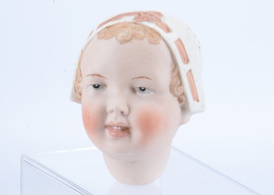 Lot 564 - A German bisque character baby head with moulded bonnet