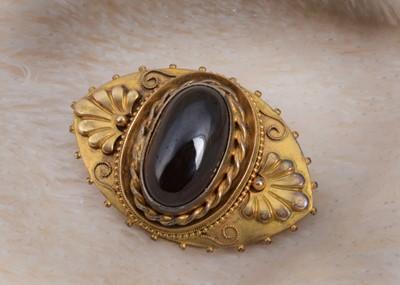 Lot 67 - A pinchbeck and garnet oval brooch