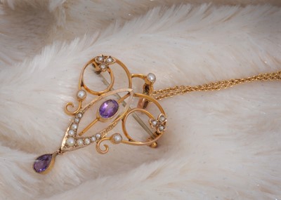 Lot 87 - An art nouveau 9ct gold amethyst and seed pearl heart shaped pierced necklace