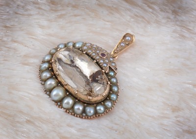 Lot 140 - A 19th Century foil backed paste set seed pearl and ruby ouroboros pendant