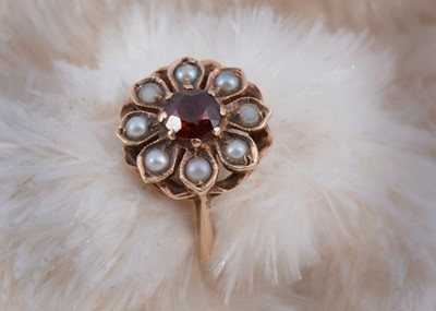 Lot 234 - A 9ct gold garnet and seed pearl flower ring
