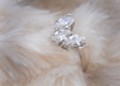 Lot 256 - A three stone 18ct white gold diamond set wishbone dress ring