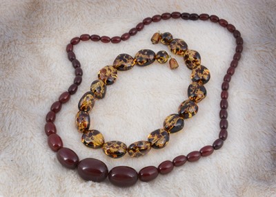 Lot 262 - A string of graduated 'cherry amber' oval bead necklace