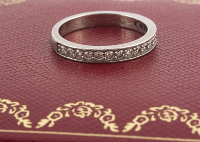 Lot 138 - A platinum and diamond Cartier cased and certificated half hoop eternity ring