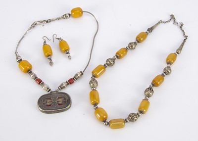 Lot 175 - A North African amber and white metal pendant and chain necklace