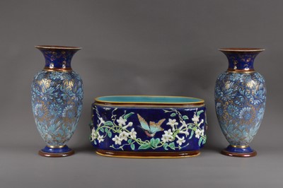 Lot 393 - A pair of Royal Doulton stoneware vases, blue ground with floral design and heightened gilt work, impressed marks to the undersides, both 35cm high